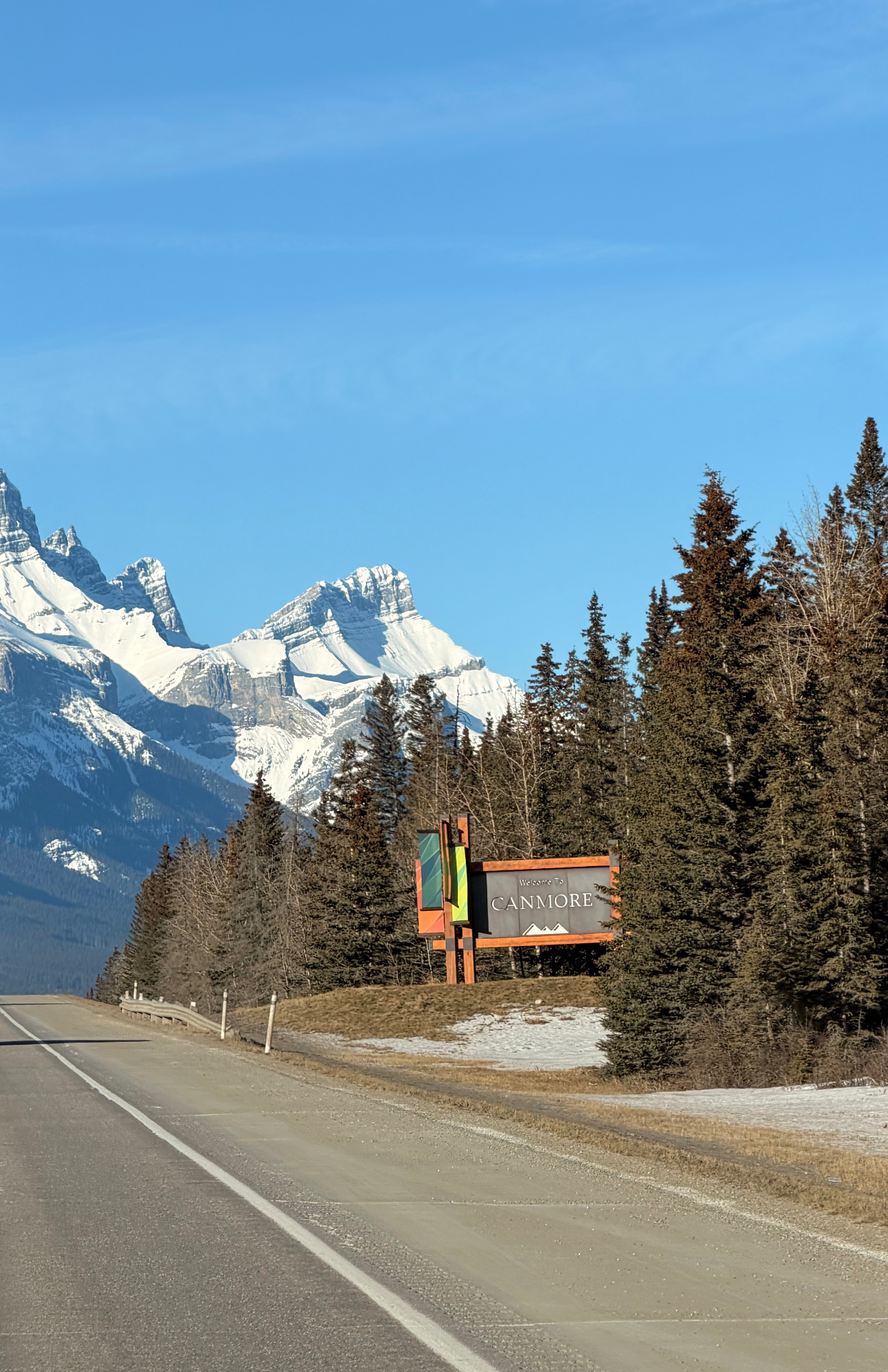 Welcome to Canmore sign with Rockies beyond