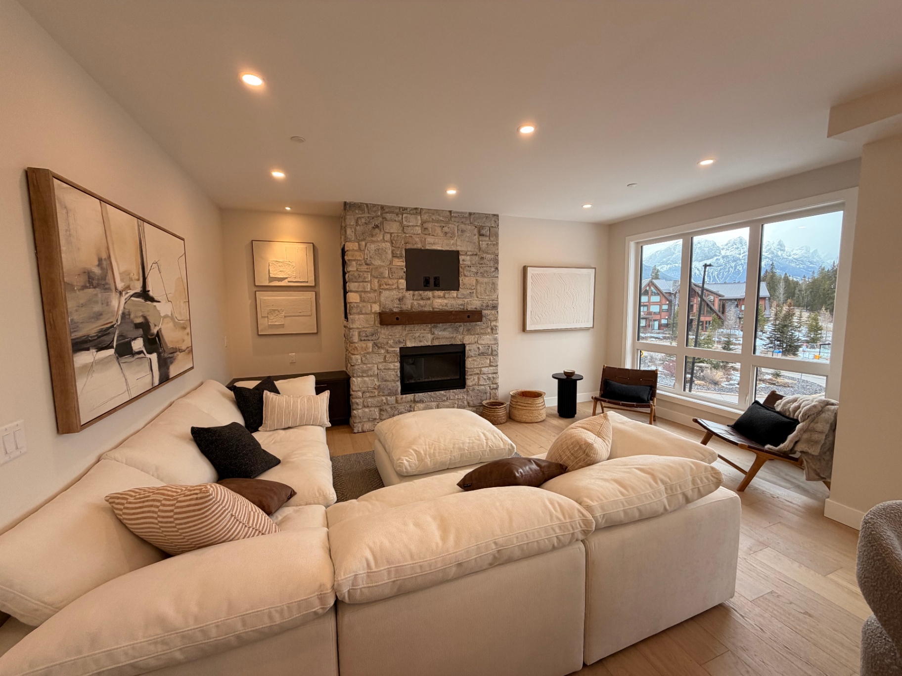 Living room with stone fireplace and mountain view